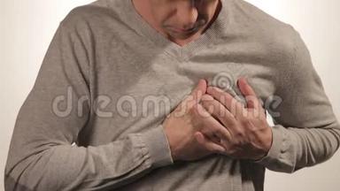 男子双手抱胸，有心脏病发作或疼痛痉挛，压在胸部，白色b上有痛苦的表情